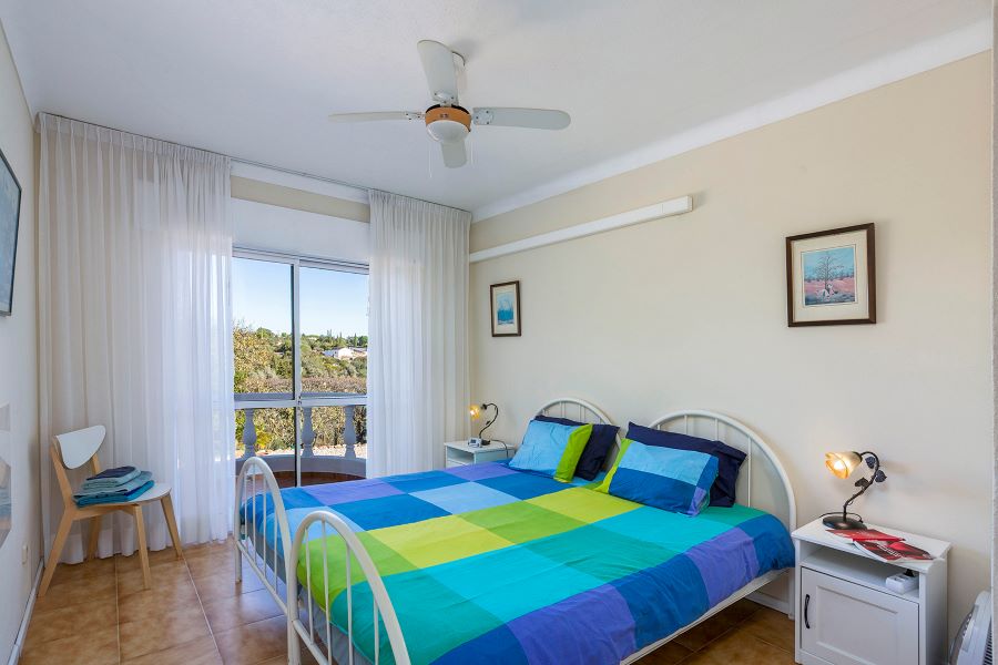 Tweede slaapkamer met klein balkon met mooi uitzicht. Gedeelde badkamer met douche en twee wastafels en toilet