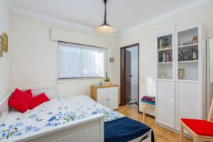 Uitgeschoven bedbank voor 2 personen. Kastruimte met boeken. Deze deelt de familiebadkamer.